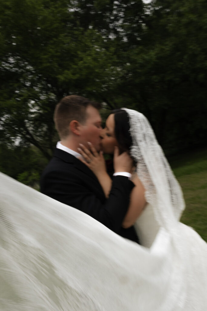 Bride and groom sharing a kiss outdoors