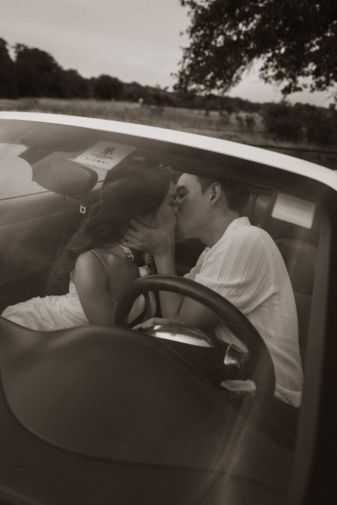 Couple kissing inside a vintage car