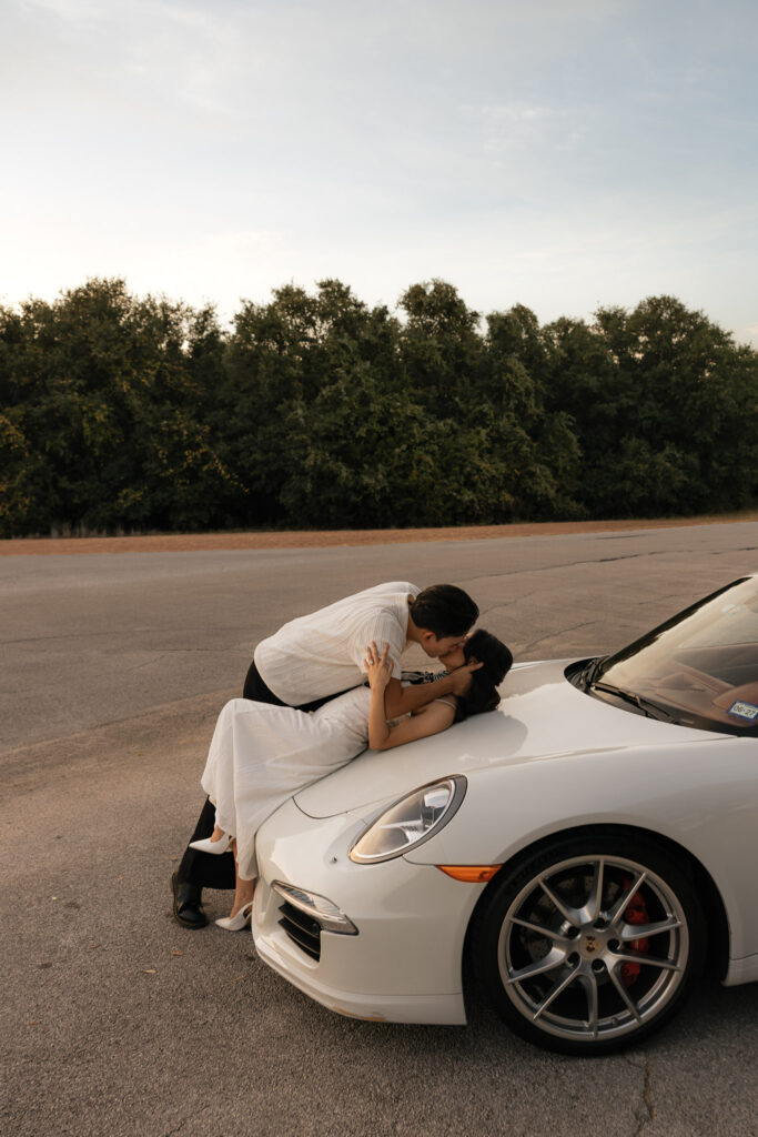 Couple kissing on white vintage car