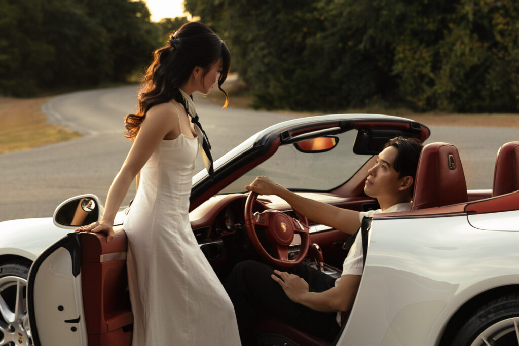 Couple with luxury sports car on scenic road