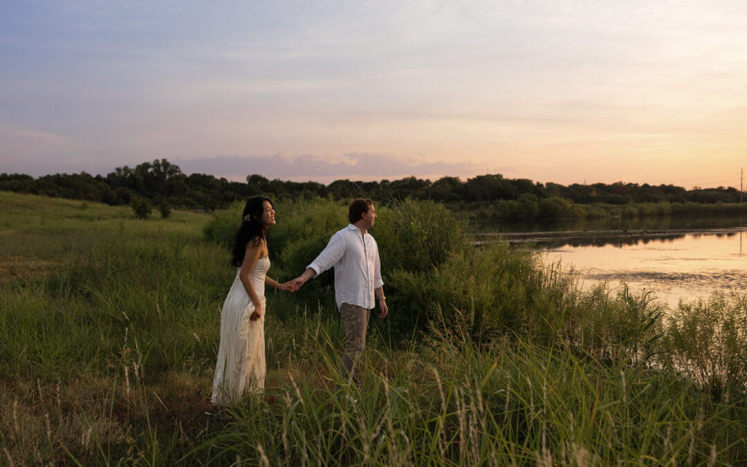 Couple holding hands by a lake during sunset