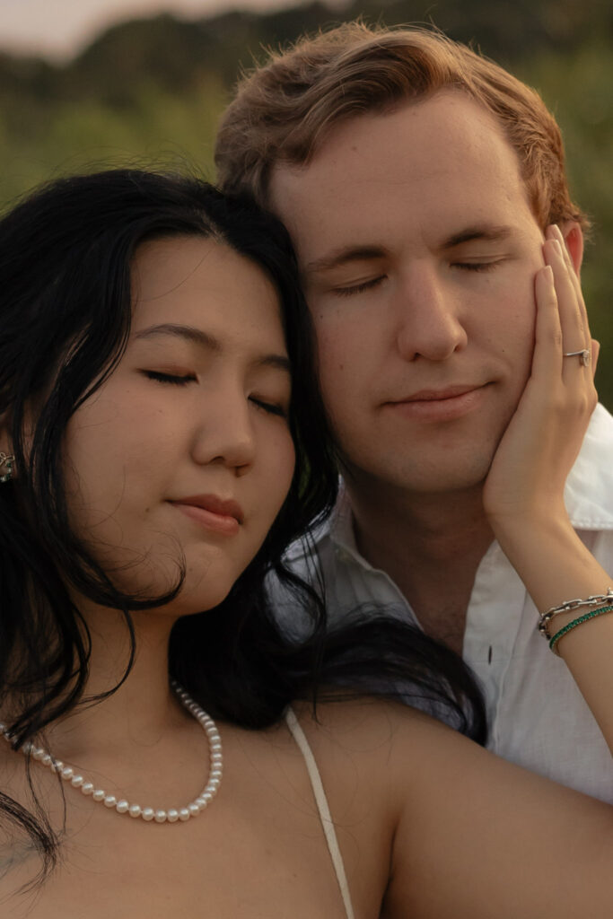Couple embracing with closed eyes outdoors.