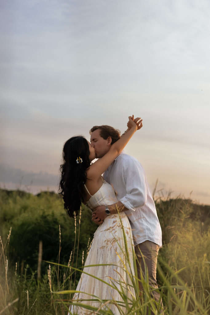 Couple embracing at sunrise on a grassy lakeside