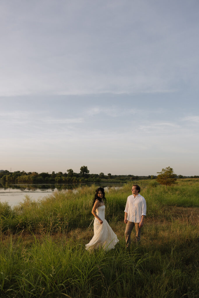 Couple walking by a lakeside at sunrise