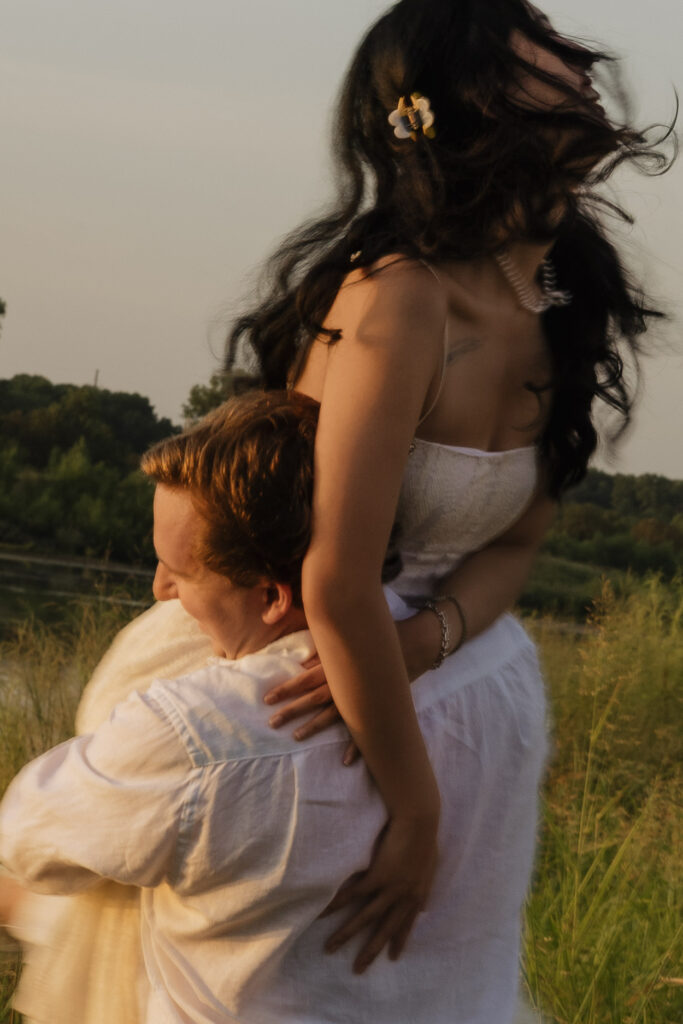 Couple enjoying playful moment by the lakeside at sunset