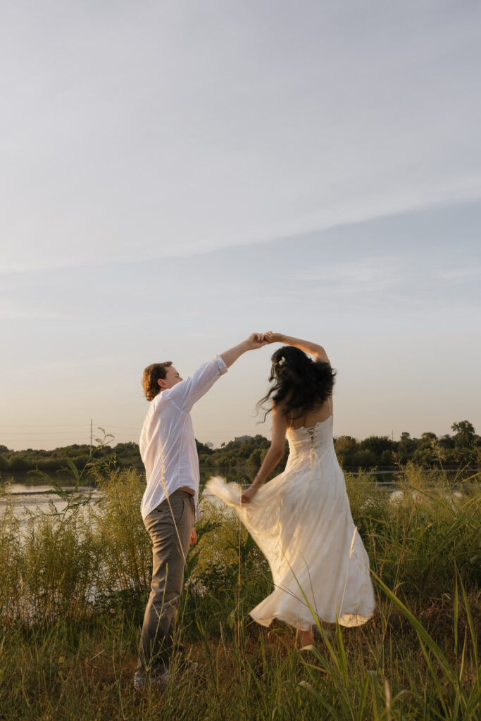 Couple dancing by a lakeside at sunrise