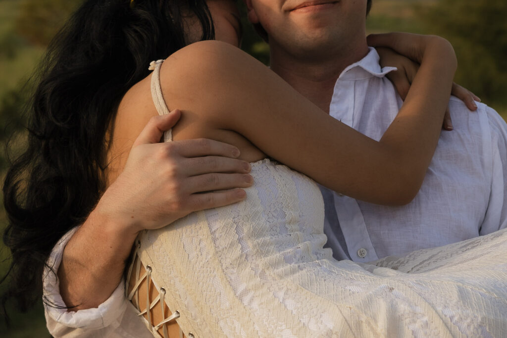 Couple embracing during a lakeside engagement photo shoot
